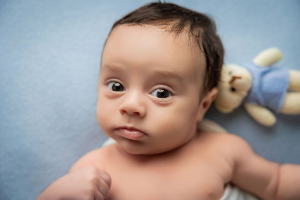 Bambino con gli occhi spalancati e il peluche
