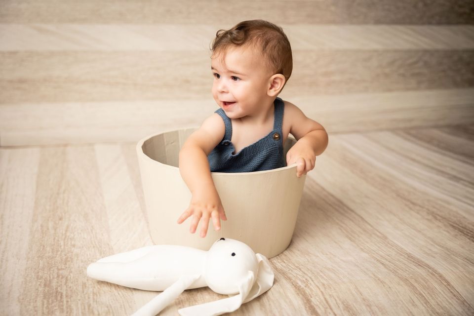 Bambino dentro un mastello di legno con il coniglietto