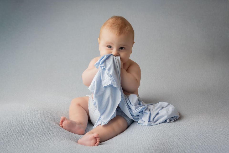 Bambino seduto che gioca con un telo