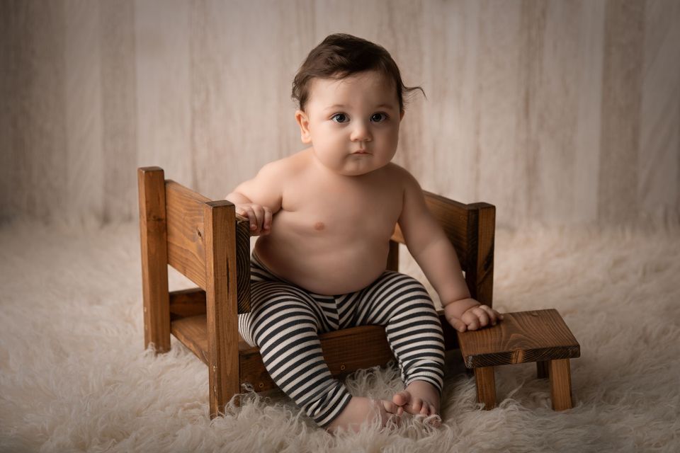 Bambino seduto su una sedia di legno