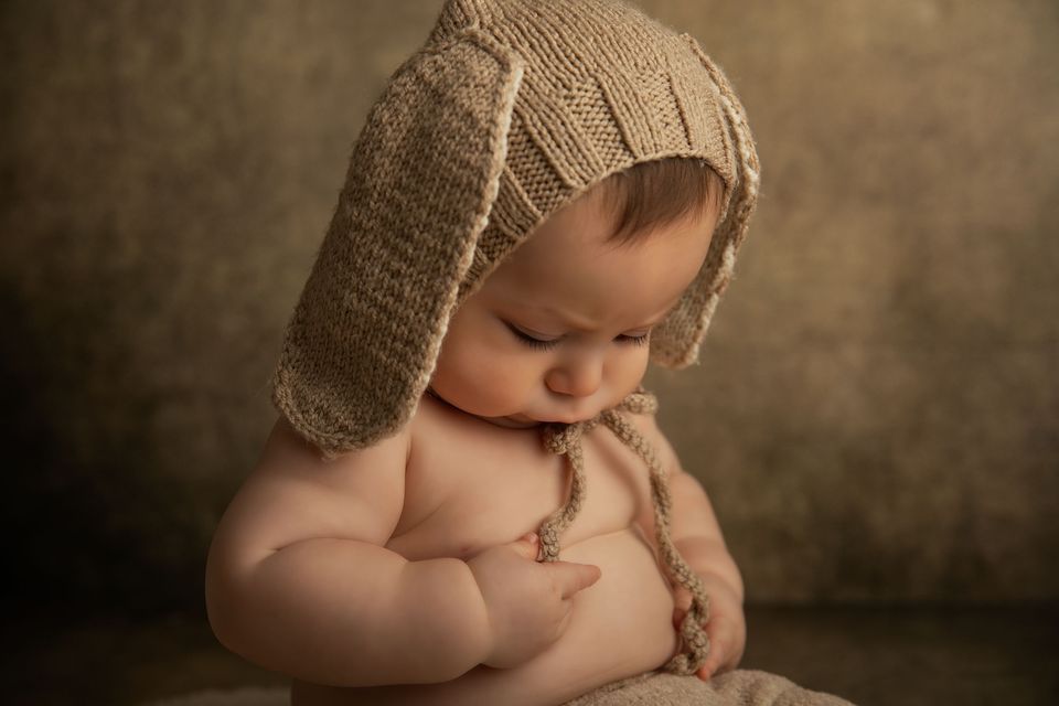 Neonato con il cappellino di lana, seduto