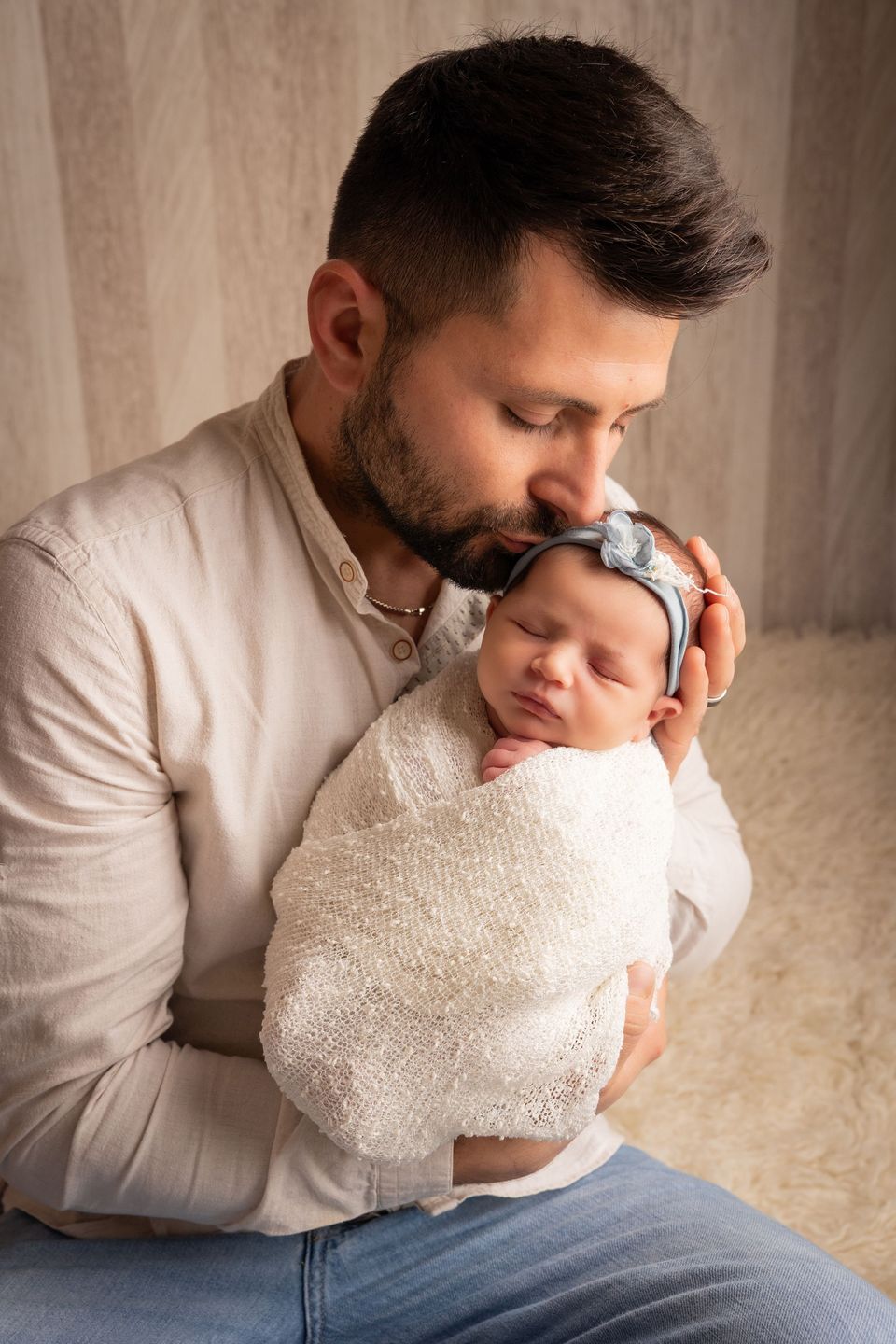 Papà seduto che tiene la neonata addormentata