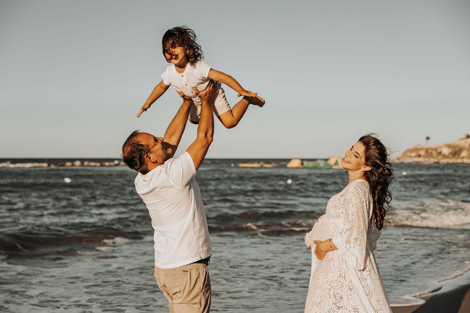 Papà solleva il bambino in riva al mare