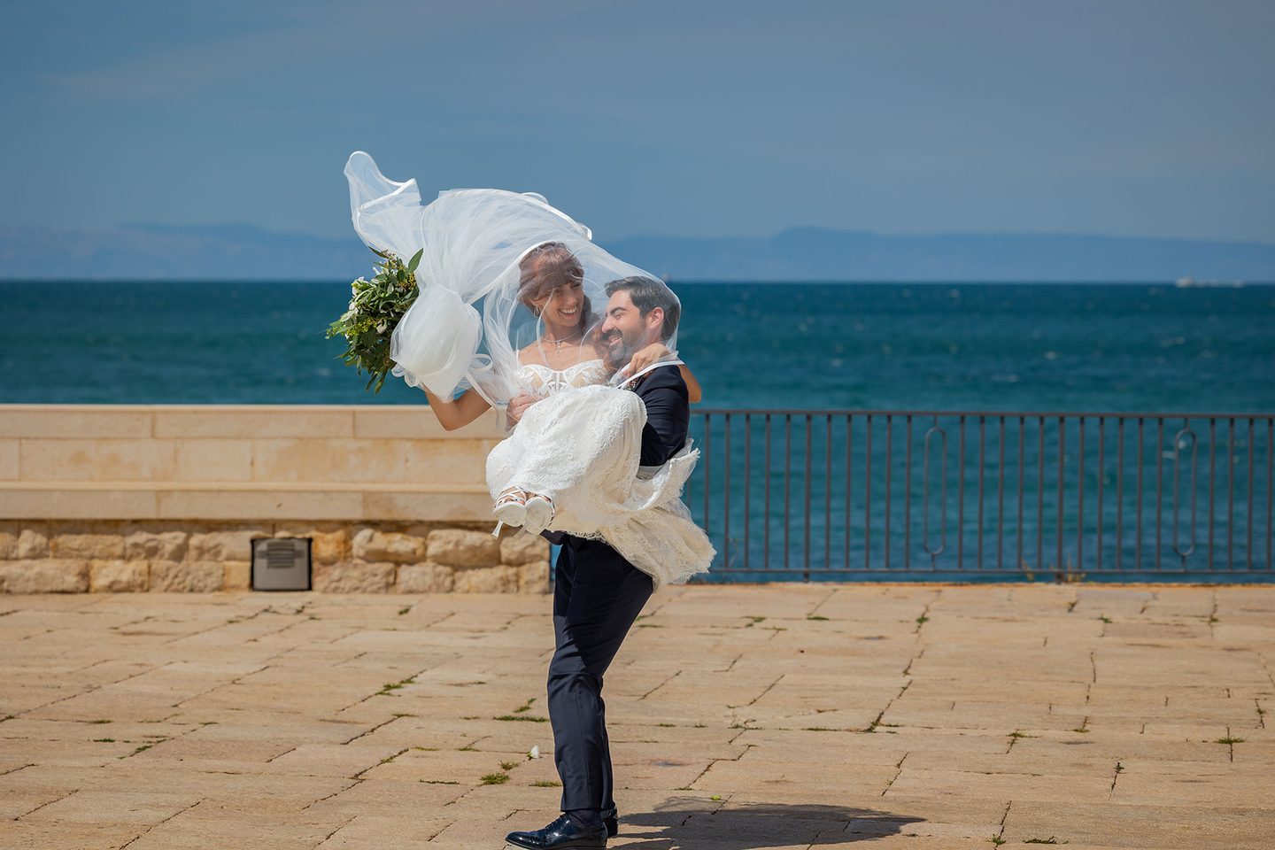 Lo sposo porta la sposa lungomare